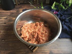 调制猪肉馅。
猪肉馅选用肥瘦比例三七的，放入姜末，少许的胡椒粉、生抽、料酒、鸡精、1个鸡蛋、黄豆酱、蚝油、适量的盐，朝一个方向搅拌均匀，然后暂时先放2g的老抽，朝一个方向搅拌调匀，大约调100下，再放入2g的老抽，继续朝一个方向调匀，调约100下，搅拌均匀后肉馅出现粘性即可。最后放入葱花，在葱花上放约10g左右的香油，先用香油把葱花拌匀，再将葱花与肉馅充分调匀，即继续朝一个方向搅拌均匀，大约搅拌100下左右即可。 
先用油裹住葱花的目的是防止葱汁外溢，造成肉馅葱味过重。