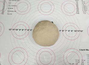 把面粉倒入碗中，加入热水，用筷子搅拌均匀，稍微凉一下之后合成面团，盖上湿布松弛30分钟。