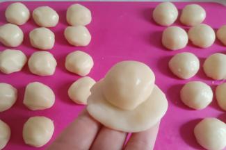 取一个油酥面团从中间分别往上、往下轻轻擀开。