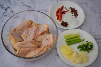 鸡翅洗净用厨房纸擦干水分然后在前后表面各切两刀，姜切片，蒜切片，葱切寸段，小葱切葱花