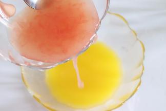 黄油隔热水融化成液态，并用黄油液在模具内部薄薄的刷一层，防沾。百香果汁倒入黄油液中，搅拌均匀，放置到温水中保持大约30多度的温度。