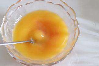 保温的西柚黄油液，再搅拌匀一下，之后顺着刮刀倒入蛋盆中，让液体和蛋糊混合匀，这里也是需要翻拌的方式，直到液体混合进去。