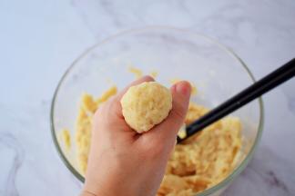 锅中加入适量的清水烧开后转小火，用虎口挤出丸子的形状