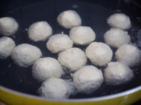 依次把丸子放入锅中，改大火烧至丸子浮在水面