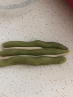 我漏拍了巧克力大理石的图片，这里以抹茶图片为例解释一下。取15克巧克力皮，分三份搓成长条，10克牛奶皮，分2份搓成长条，按图摆放，拧成麻花状。