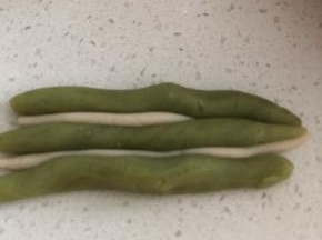 我漏拍了巧克力大理石的图片，这里以抹茶图片为例解释一下。取15克巧克力皮，分三份搓成长条，10克牛奶皮，分2份搓成长条，按图摆放，拧成麻花状。