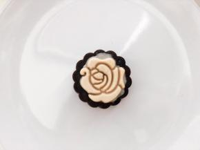 玫瑰图案的月饼：模具滚一遍低粉防粘，取4克牛奶味的桃山皮，压扁，直径如图案大小，放在模具中间，手指沾一点水点一下牛奶皮中间，方便一会与巧克力皮粘合，21克的巧克力桃山皮包好馅料后也放入模具，压出月饼。
