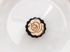 玫瑰图案的月饼：模具滚一遍低粉防粘，取4克牛奶味的桃山皮，压扁，直径如图案大小，放在模具中间，手指沾一点水点一下牛奶皮中间，方便一会与巧克力皮粘合，21克的巧克力桃山皮包好馅料后也放入模具，压出月饼。