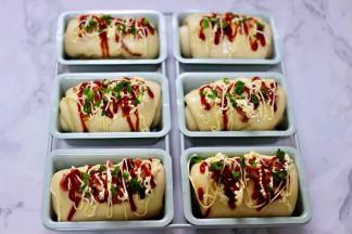 再放上用刀切碎的培根块，挤上沙拉酱和番茄酱后，最后撒上葱花。