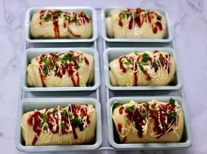 再放上用刀切碎的培根块，挤上沙拉酱和番茄酱后，最后撒上葱花。