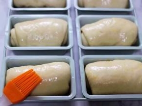 二发好的面包胚，是原来的两倍大，刷上一层蛋液。