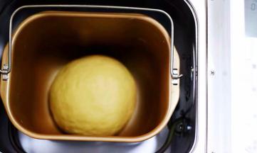 面团整成圆形，放入面包机里。