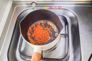 锅里放少许油加入胡萝卜丁翻炒