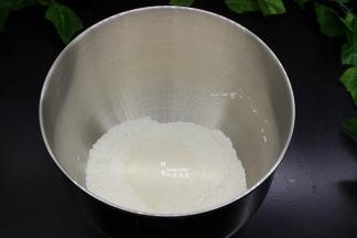 把高筋粉、低筋粉、奶粉、白砂糖、盐放入厨师机的桶里拌均，然后倒入蛋液；