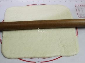 中间发酵好的面团，用擀面杖擀成方形的薄片，大小和烤盘一致。我用烤盘是28*28cm