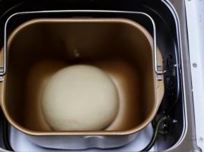 启动面包机后，开启和面模式后，用手揉圆面团后，放入面包机开始醒发状态。