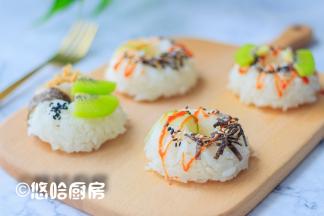 将模具倒扣在案板上，饭团就是完整的甜甜圈形状，用黄瓜片、海苔片从饭团中间缠一道，在饭团上摆上肉松、猕猴桃、黑芝麻、海苔碎等，淋上番茄沙司装饰一下即可。