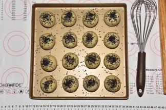 在蛋黄酥顶部刷蛋黄水，撒芝麻