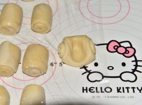 将小卷子从接口处按一个窟窿，两边向中间按，形成一个圆饼状