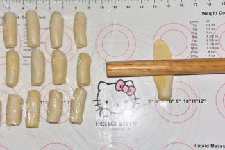 将卷好的面团从接口处纵向擀长，再次卷起来