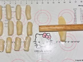 将卷好的面团从接口处纵向擀长，再次卷起来