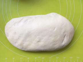 将面团按压排出大气泡，之后将面团揉至表面光滑，盖保鲜膜松弛；