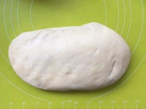 将面团按压排出大气泡，之后将面团揉至表面光滑，盖保鲜膜松弛；