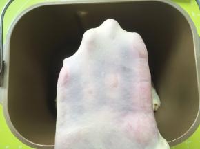 加入冰牛奶，启动揉面程序，将材料揉成面团，揉好的面团呈扩展状态，切下一小块可以撑出厚一点的手套膜，破口处呈锯齿状；
