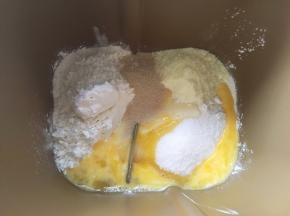 面包桶内加入高筋面粉、低筋面粉、细砂糖、全蛋液、奶粉、15克炼乳跟酵母；