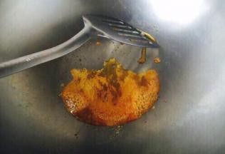 冰糖刚开始融化后的状态如图中中间部分，图中左右两边已经产生气泡，当中间部分也产生气泡后用铲子迅速滑动，