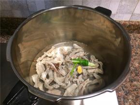 将肚条放入高压锅中放入小葱、花椒、料酒和姜片上汽后压20分钟。