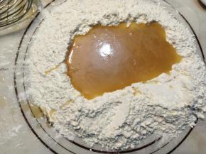 在面粉中间开个小天窗，把拌匀的糖浆倒进去。