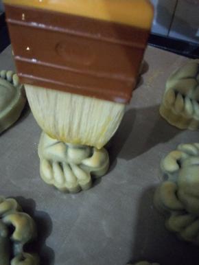 定型后室温放至手温，把蛋黄、牛奶加上2滴油搅拌均匀，然后在放凉的小螃蟹表面轻轻的、迅速的刷上一层蛋液，蛋液一定不要过多，用毛尖处反复刷2次即可。