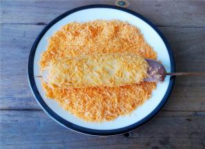 再拿起来卷好芝士片的香肠在面包糠中滚一圈，使其沾满面包糠