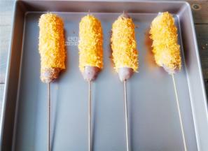 把裹满面包糠的香肠依次摆放在学厨金盘上，之间要留有间隔哦！