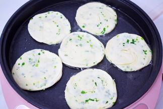 电饼档烧热倒入食用油，放入葱油饼坯