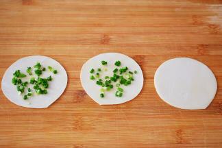 三个饺子皮为一组，其中两个放入葱馅，一个不放