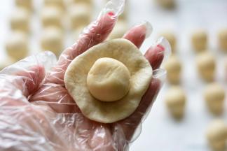 取一个油皮擀成圆形，把油酥放在油皮上面，用油皮包住油酥，慢慢用虎口

往上收，最后慢慢的收口，直到油皮完全把油酥包裹住，这个过程和包蛋黄

的操作是一样的。