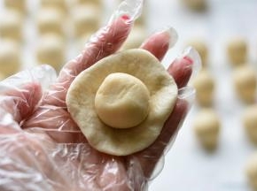 取一个油皮擀成圆形，把油酥放在油皮上面，用油皮包住油酥，慢慢用虎口

往上收，最后慢慢的收口，直到油皮完全把油酥包裹住，这个过程和包蛋黄

的操作是一样的。