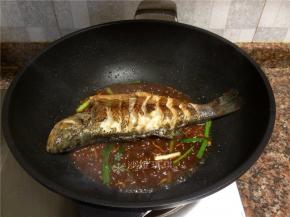 放入鱼，用铲子将酱汁浇在鱼身上，然后翻面重复浇酱汁。（全程小火）