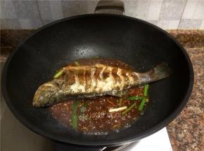 放入鱼，用铲子将酱汁浇在鱼身上，然后翻面重复浇酱汁。（全程小火）