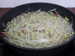 把豆芽加入翻炒变软，加入适量的清水煮沸。