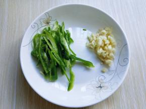 青椒洗干净，去根，去籽，切丝，大蒜去皮，切碎。