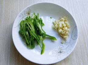 青椒洗干净，去根，去籽，切丝，大蒜去皮，切碎。