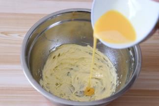 取20g蛋液分三次倒入到黄油中，每一次都要用打蛋器搅打均匀后再倒下一次的蛋液；