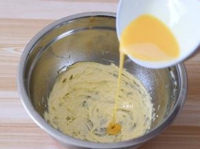 取20g蛋液分三次倒入到黄油中，每一次都要用打蛋器搅打均匀后再倒下一次的蛋液；