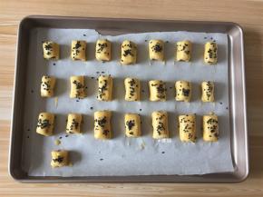 卷起来再切成小段，一一摆入烤盘中，刷上剩余的蛋液撒上黑芝麻；