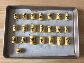 卷起来再切成小段，一一摆入烤盘中，刷上剩余的蛋液撒上黑芝麻；