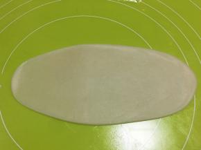 取一份包裹好的面团，用擀面杖擀成长条