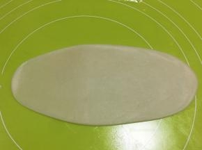 取一份包裹好的面团，用擀面杖擀成长条